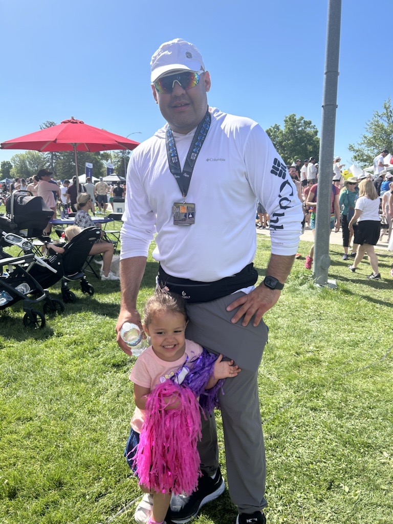 Program Officer, Juan Escobedo, with his daughter after finishing the Denver Colfax Marathon